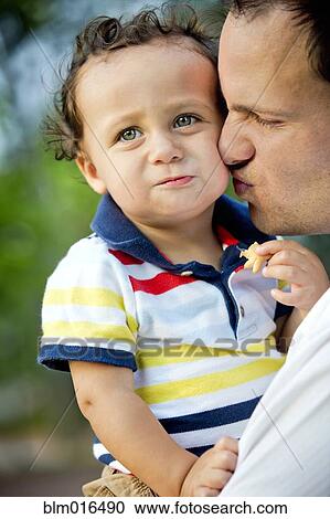 Stock Image - Father kissing son's cheek. Fotosearch