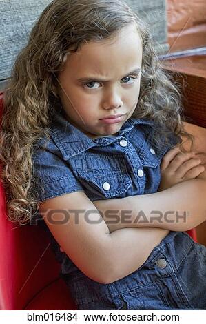 Frowning mixed race girl sitting in chair View Large Photo Image Picture - Frowning mixed race girl sitting in chair. Fotosearch