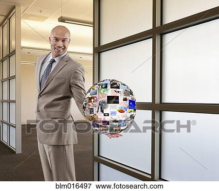 Stock Photo - Hispanic businessman holding illustration of globe. Fotosearch
