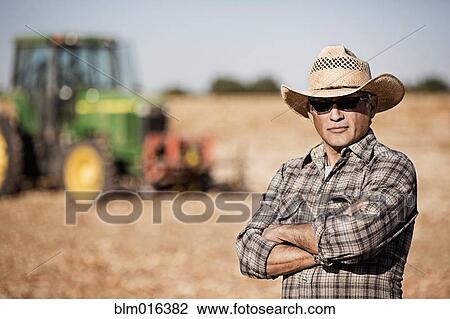 Hispanic farmer standing by harvester View Large Photo Image Stock Image - Hispanic farmer standing by harvester. Fotosearch