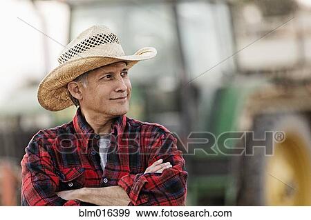 Hispanic farmer standing by harvester View Large Photo Image Stock Photo - Hispanic farmer standing by harvester. Fotosearch