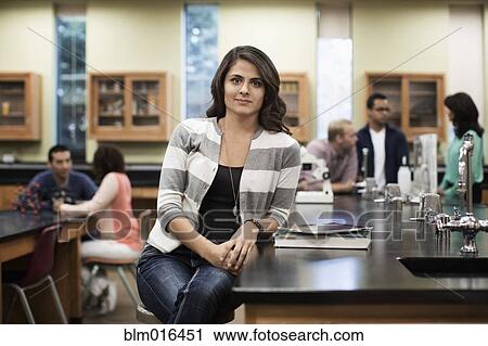 Stock Image - Hispanic student sitting at desk in lab classroom. Fotosearch