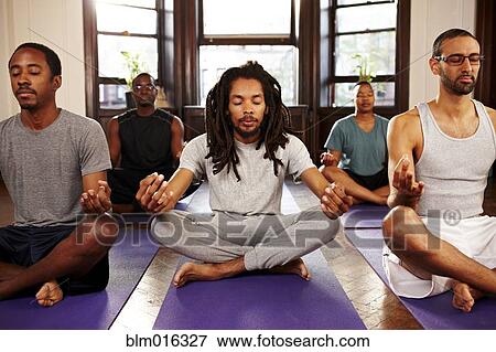 Stock Photo - Men meditating in yoga class. Fotosearch