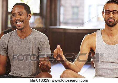 Stock Photo - Men meditating in yoga class. Fotosearch