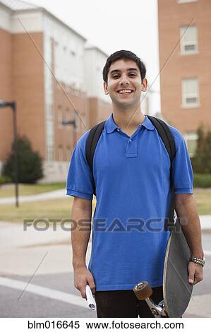 Middle Eastern student carrying skateboard View Large Photo Image Stock Photography - Middle Eastern student carrying skateboard. Fotosearch