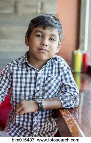 Stock Photo - Mixed race boy sitting in restaurant. Fotosearch