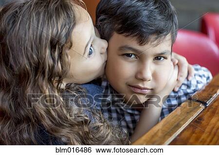 Mixed race girl kissing frowning boy View Large Photo Image Stock Photograph - Mixed race girl kissing frowning boy. Fotosearch
