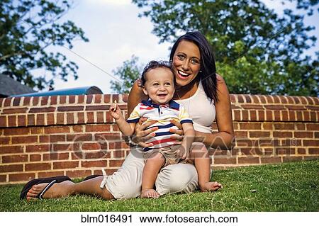Mixed race mother and son sitting in grass View Large Photo Image Stock Image - Mixed race mother and son sitting in grass. Fotosearch