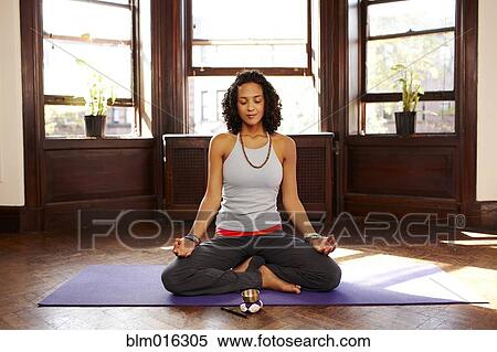 Mixed race woman practicing yoga in living room View Large Photo Image Stock Photography - Mixed race woman practicing yoga in living room. Fotosearch