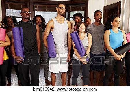 Stock Image - People holding yoga mats. Fotosearch