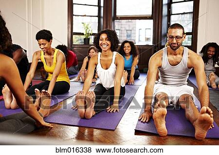 Stock Photo - People practicing yoga in class. Fotosearch