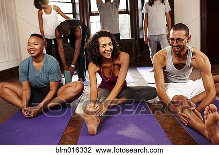 Stock Image - People stretching in yoga class. Fotosearch