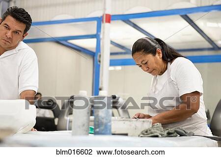 Stock Image - People working in manufacturing plant. Fotosearch