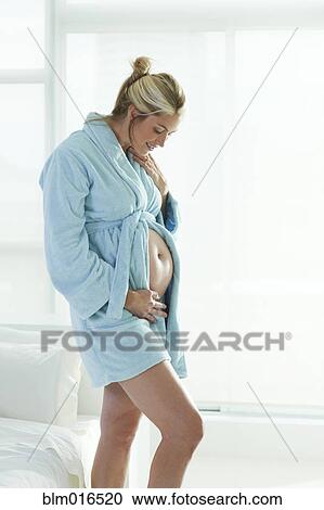 Stock Image - Pregnant Caucasian woman holding stomach. Fotosearch
