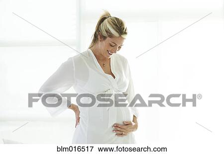 Stock Photo - Pregnant Caucasian woman holding stomach. Fotosearch