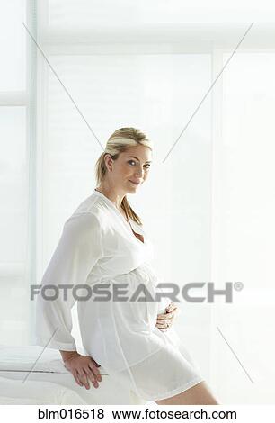 Stock Photo - Pregnant Caucasian woman holding stomach. Fotosearch