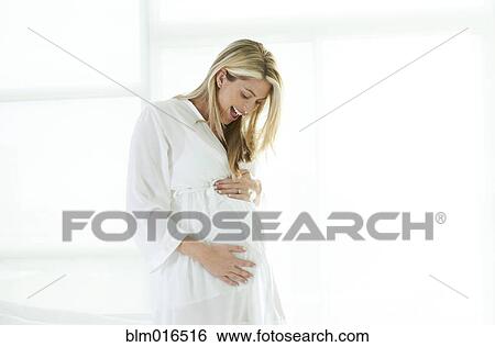 Stock Photograph - Pregnant Caucasian woman holding stomach. Fotosearch