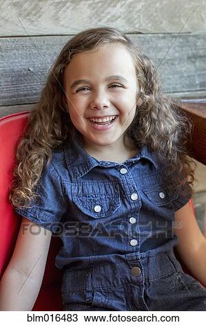 Smiling mixed race girl sitting in chair View Large Photo Image Stock Image - Smiling mixed race girl sitting in chair. Fotosearch