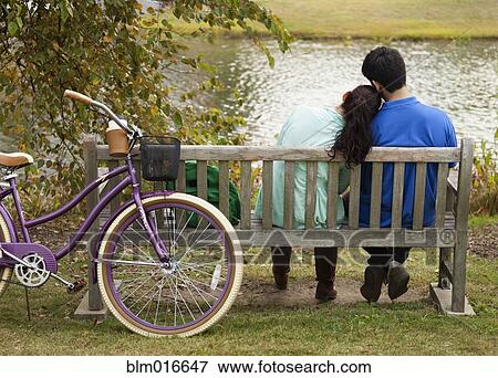 Student couple sitting on park bench View Large Photo Image Stock Photo - Student couple sitting on park bench. Fotosearch