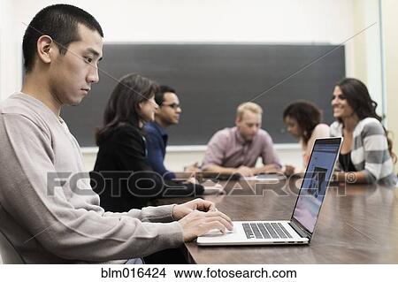 Picture - Student using laptop in classroom. Fotosearch