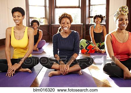 Stock Image - Women smiling in yoga class. Fotosearch
