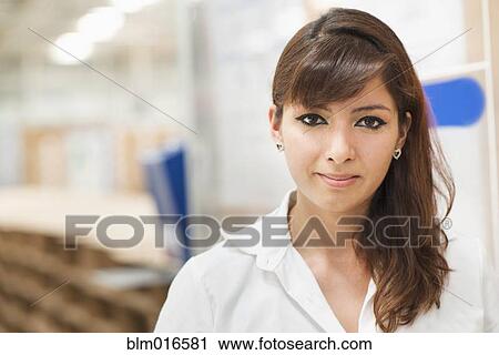 Stock Image - Worker smiling in manufacturing plant. Fotosearch