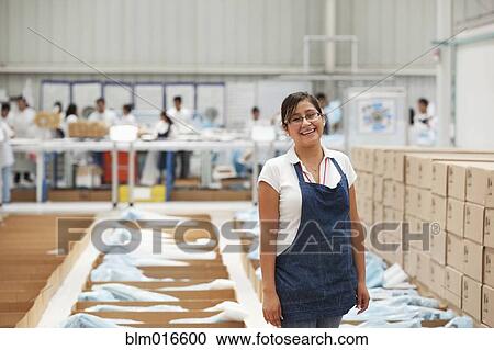 Worker smiling in manufacturing plant View Large Photo Image Stock Image - Worker smiling in manufacturing plant. Fotosearch