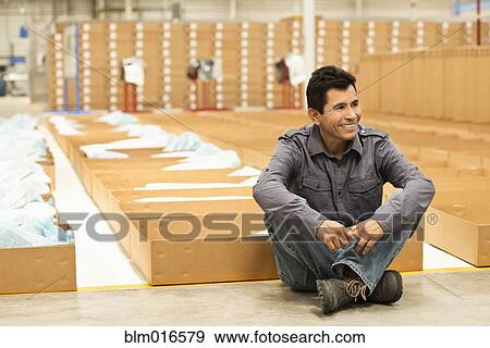 Worker smiling in manufacturing plant View Large Photo Image Stock Photo - Worker smiling in manufacturing plant. Fotosearch