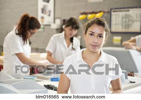 Stock Photography - Worker smiling in manufacturing plant. Fotosearch