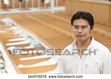 Stock Photo - Worker standing in manufacturing plant. Fotosearch