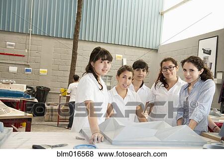 Stock Photo - Workers talking in manufacturing plant. Fotosearch