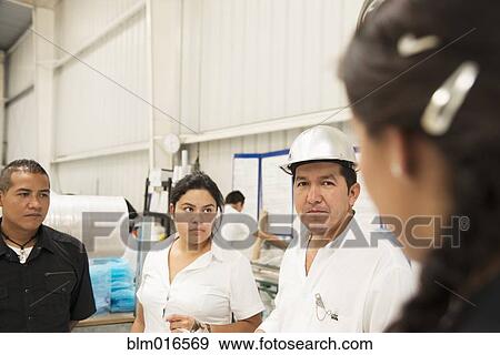 Workers talking in manufacturing plant View Large Photo Image Stock Photo - Workers talking in manufacturing plant. Fotosearch
