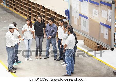 Stock Photograph - Workers talking in manufacturing plant. Fotosearch