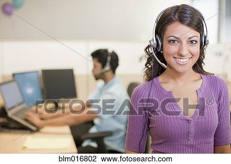Stock Image - Asian businesswoman wearing headset. Fotosearch