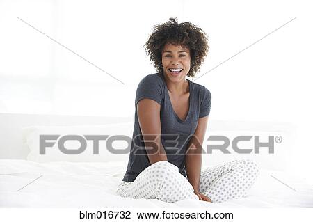 Black woman sitting on bed View Large Photo Image Stock Image - Black woman sitting on bed. Fotosearch
