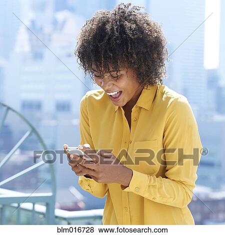 Stock Photo - Black woman using cell phone. Fotosearch