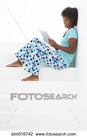 Stock Image - Black woman using tablet computer. Fotosearch