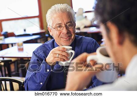 Businessmen having coffee together in cafe View Large Photo Image Stock Image - Businessmen having coffee together in cafe. Fotosearch