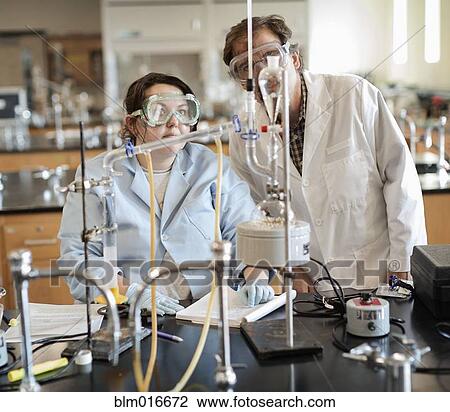 Stock Image - Caucasian students working in chemistry lab. Fotosearch
