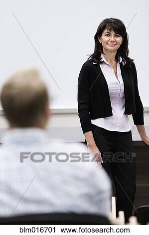 Stock Image - Caucasian teacher talking to student. Fotosearch