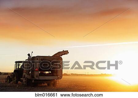 Stock Image - Farming machinery in crop field. Fotosearch