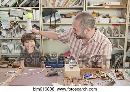 Stock Photo - Father and son playing in workshop. Fotosearch