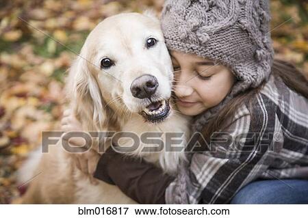 Girl hugging dog in autumn leaves View Large Photo Image Stock Photo - Girl hugging dog in autumn leaves. Fotosearch