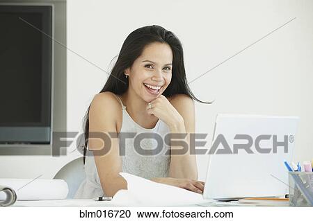 Stock Image - Hispanic businesswoman working in office. Fotosearch