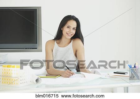 Stock Photography - Hispanic businesswoman working in office. Fotosearch