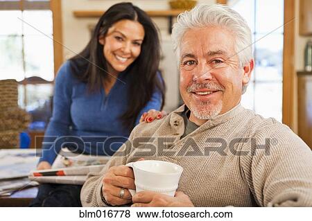 Stock Photo - Hispanic couple smiling in living room. Fotosearch