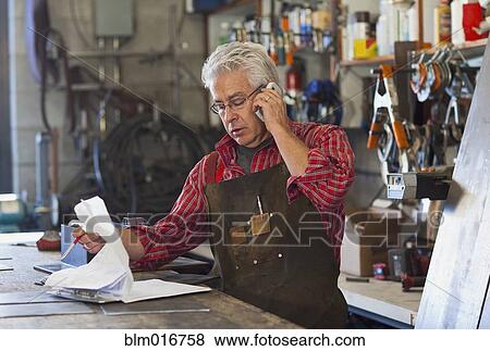 Stock Photo - Hispanic craftsman working in shop. Fotosearch