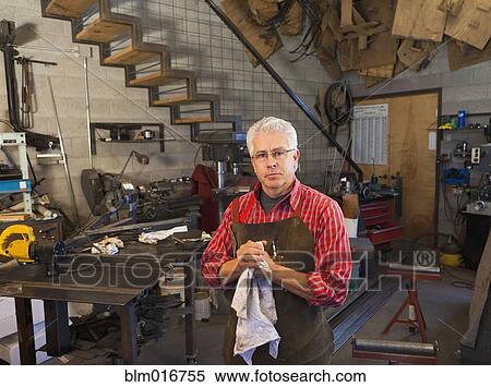 Stock Photography - Hispanic craftsman working in shop. Fotosearch