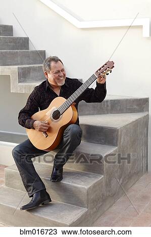 Hispanic man playing guitar on steps View Large Photo Image Stock Image - Hispanic man playing guitar on steps. Fotosearch