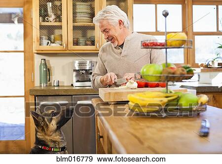 Hispanic man with begging dog in kitchen View Large Photo Image Stock Photo - Hispanic man with begging dog in kitchen. Fotosearch